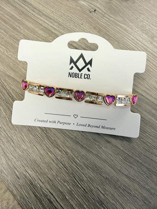 Scarlett Heart Crystal Stretch Bracelet in Berry by Noble Co. featuring alternating faceted heart-shaped and baguette-cut crystals in polished gold-tone settings.
